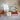 Small cross ornament on a stand with green ribbon against a blurred background