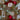 Gift wrapped in brown paper with green and red ribbons on a textured surface.