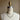 Necklace on a mannequin with a vintage-style label against a plain background