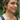 Smiling woman in a navy tank top wearing the Bennett gray and white pearl necklace