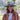 Smiling woman in a painted wide-brim hat, white tee and leather jacket wearing the Cash gold lariat necklace