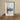 Framed artwork on a wooden surface with a neutral background