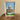 Framed artwork of an ice cream cone with a sign reading 'Sandy's Frozen Custard and Root Beer' on a wooden surface.