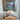 Decorative coral sculpture on a book with a framed landscape painting in the background.