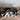 Leopard print bag with black handle on a wooden stand against a tiled floor background