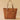 Brown leather tote bag on a beige background