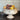 Decorative white bowl with fruit on a wooden surface and brick wall background