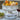 Decorative white pedestal bowl with gourds on a table with wine and grapes.