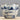 A ceramic cup with a blue and white hand-painted landscape design, featuring a rustic wooden table and mountains, set against a neutral gray background.