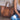 Brown leather tote bag next to a person sitting on the ground.
