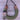 Necklace with green yarn, wooden elements, and feathers on a wooden surface