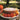 Pumpkin cake on a plate with flowers, placed outdoors.