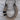 A natural hide horseshoe-shaped pendant necklace wrapped in brown and beige fur, featuring two black bands and hanging from a black cord on a weathered gray wood background.