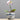 A white and purple Phalaenopsis orchid plant in a blue and white ceramic pot with a landscape design, set against a solid gray background.