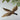 Decorative taxidermy bird hanging from a branch with a plain background
